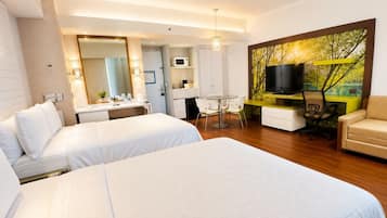 Habitación de hotel con dos camas, un escritorio con silla, televisor y un cuadro en la pared.