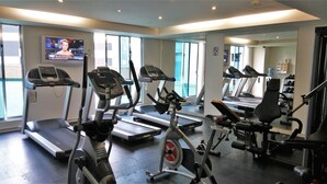 A gym with treadmills, elliptical machines, and weight equipment.