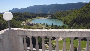 A scenic view of a lake surrounded by mountains, with a stone balustrade in the foreground. - Grand Hotel Astoria (Lavarone)