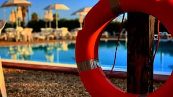 Enjoy a safe swim in our pool surrounded by lounge chairs and umbrellas.