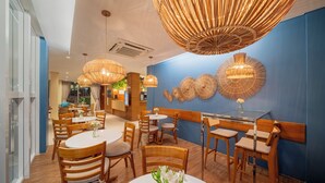 A restaurant with round tables, wooden chairs, and hanging wicker chandeliers. - Beach Park Wellness Resort (Aquiraz)