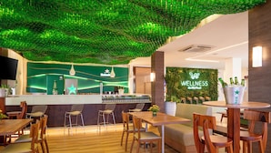 A modern wellness center with a green ceiling, wooden furniture, and a bar area with a Heineken sign. - Beach Park Wellness Resort (Aquiraz)