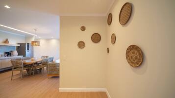 Una cocina moderna con comedor, que incluye una mesa y sillas de madera, una lámpara colgante y placas decorativas en la pared.