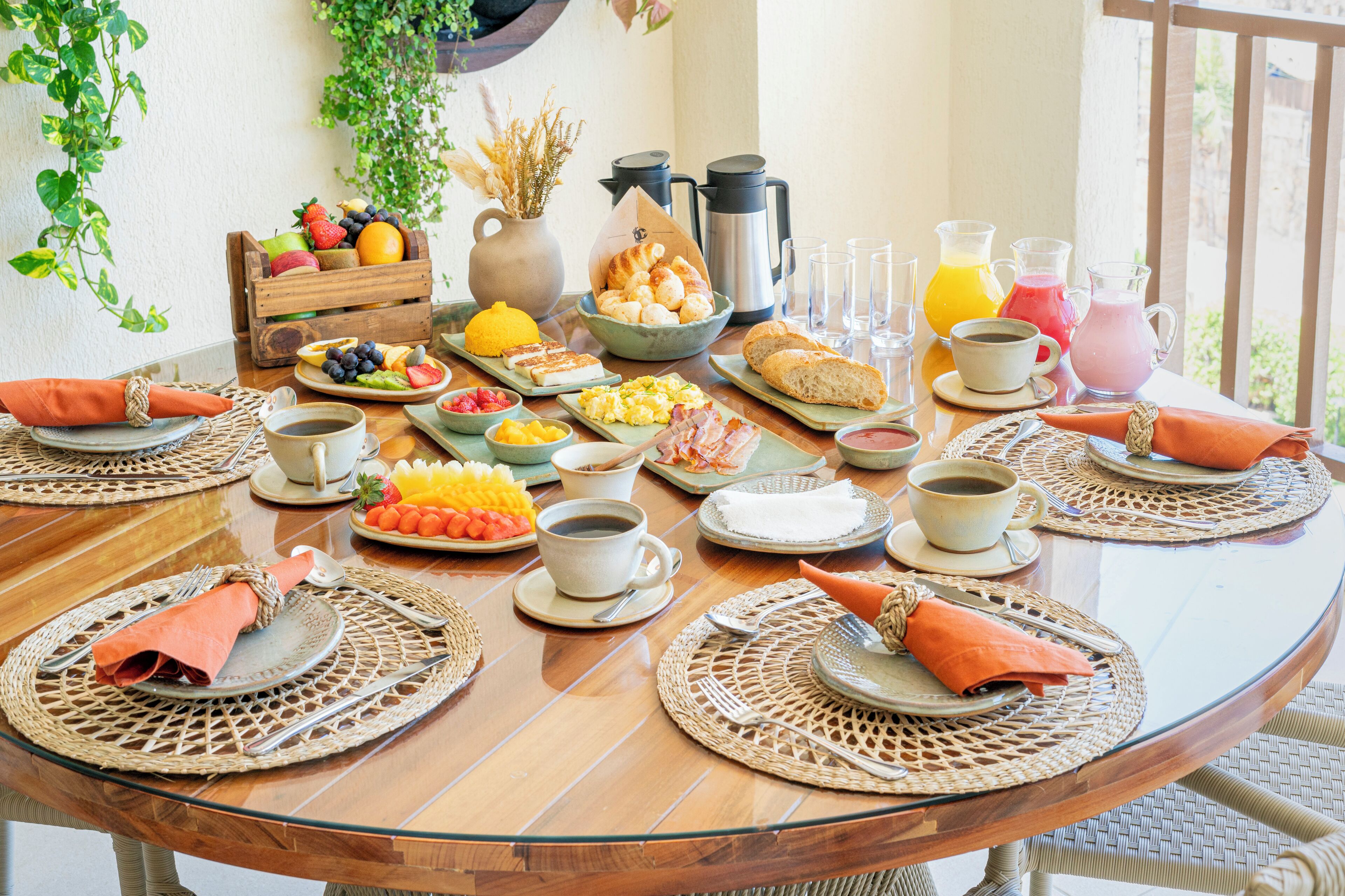 Una mesa de desayuno con diversas comidas, bebidas y tazas de café.