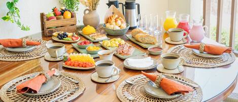 Una mesa de desayuno con diversas comidas, bebidas y tazas de café.