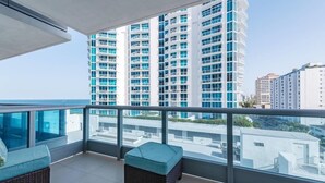 A balcony with wicker furniture and a view of tall buildings. - Churchill Suites Miami Brickell (Miami)