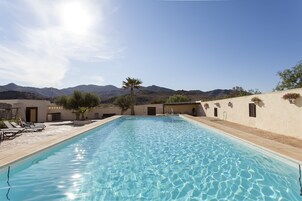 Una piscina al aire libre, tumbonas