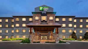 A Holiday Inn Express & Suites building with a brick facade, large windows, and a covered entrance. - Holiday Inn Express Hotel & Suites Denver Airport by IHG (Denver)