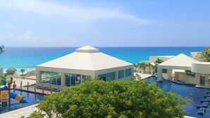 Un resort con zona de piscina, tobogán acuático y vistas al océano.