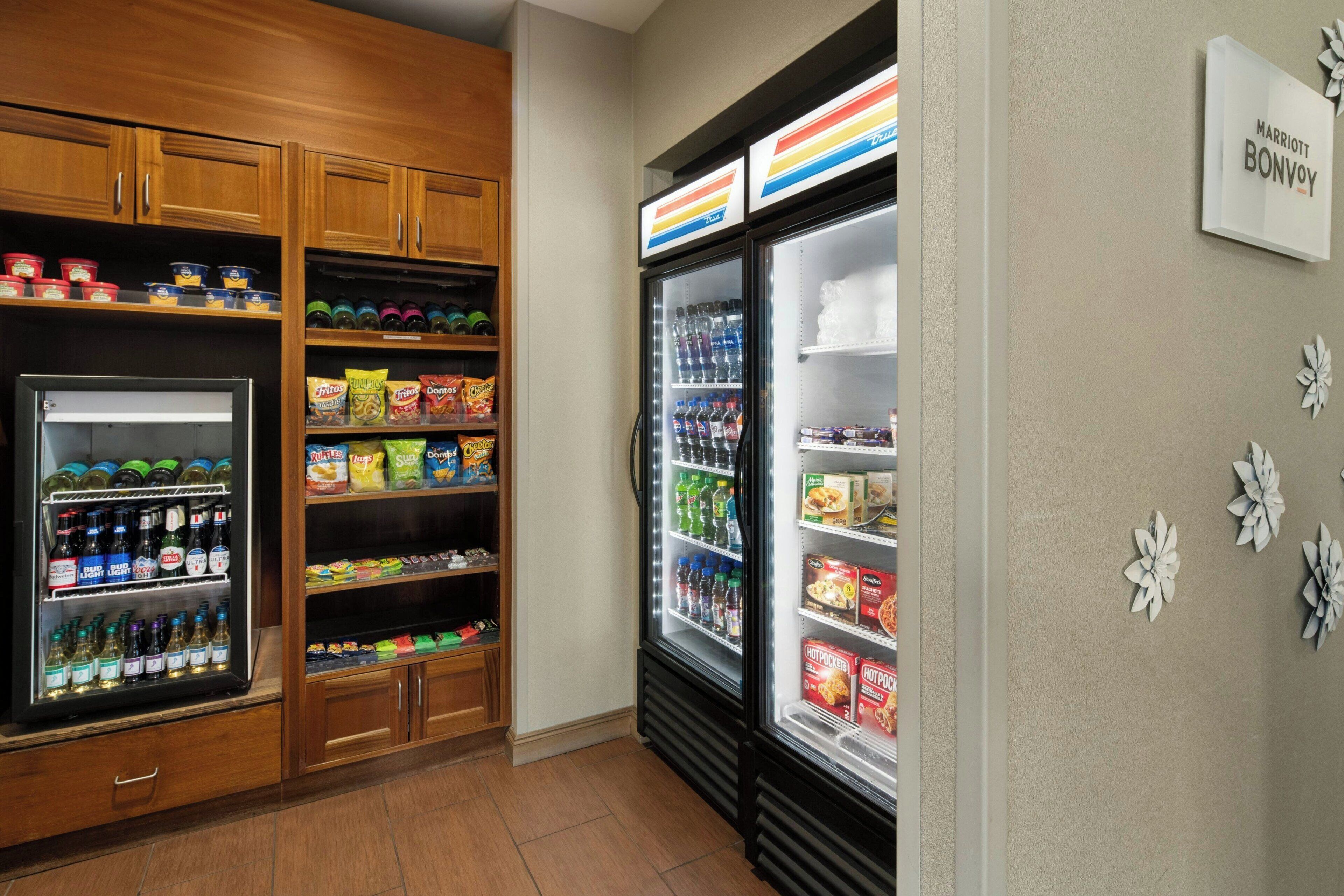 A hotel kitchenette with a refrigerator, pantry, and a sign for Marriott Bonvoy.