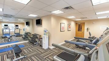 A fitness center with treadmills, dumbbells, and exercise equipment.