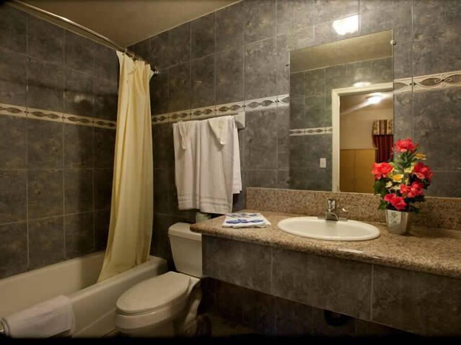Un baño con bañera, inodoro, lavabo y espejo.