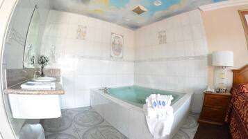 Un baño con bañera, lavamanos y espejo.