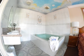A bathroom with a bathtub, a sink, and a mirror.