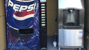 Una máquina expendedora de Pepsi y un refrigerador de acero inoxidable.