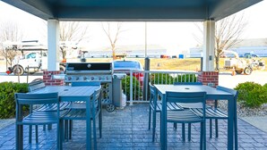An outdoor patio with a grill and seating area.