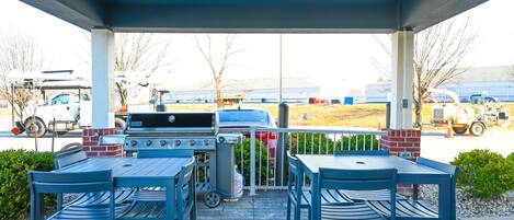 An outdoor patio with a grill and seating area.