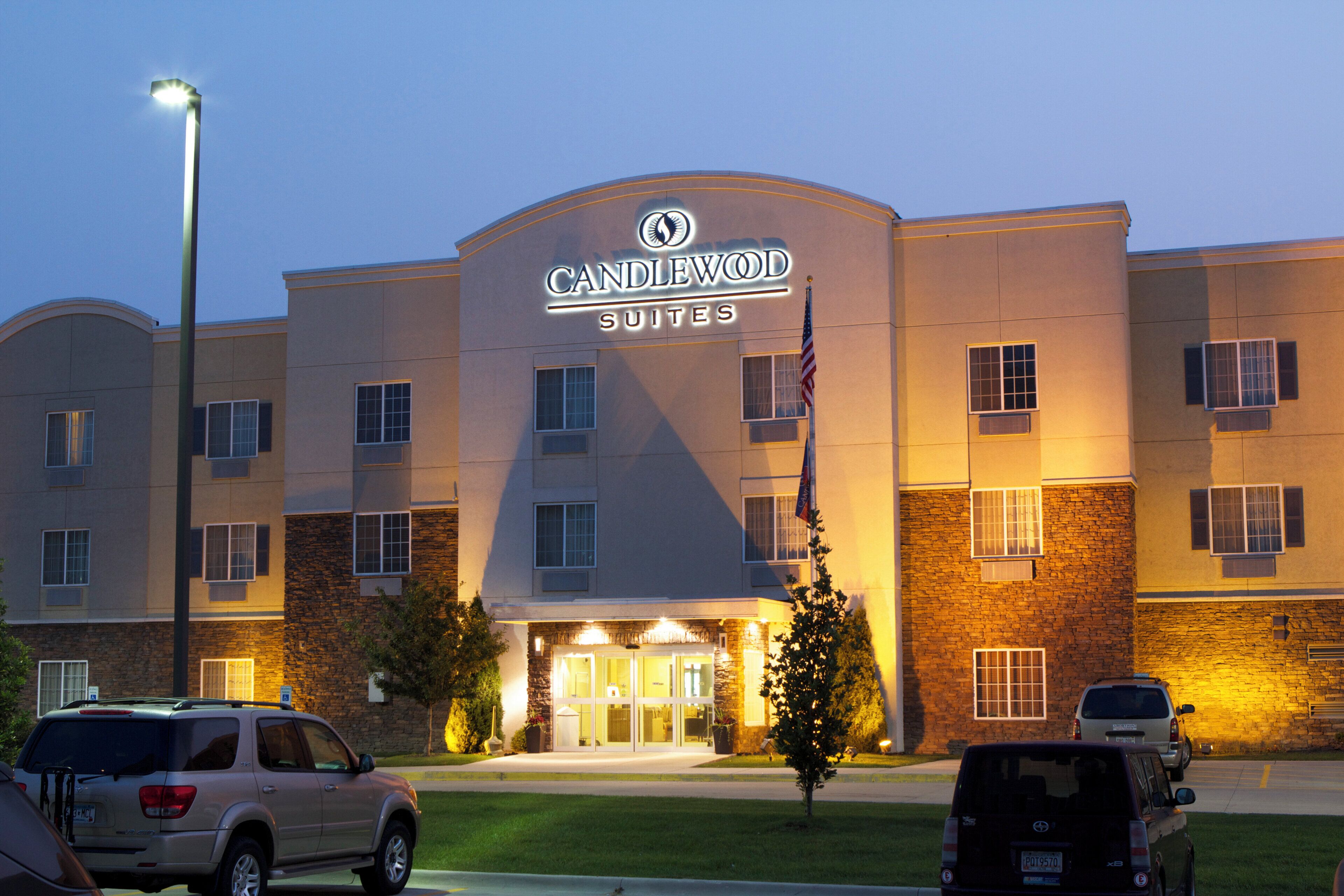 A hotel with a prominent sign, multiple windows, and a well-lit entrance.