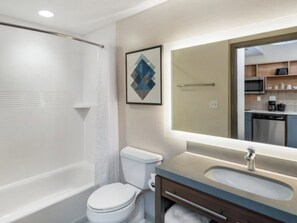 A modern bathroom with a bathtub, toilet, and sink. - Candlewood Suites Champaign-Urbana University Area by IHG (Champaign)