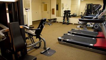 A gym with treadmills, a stationary bike, and a weight bench.
