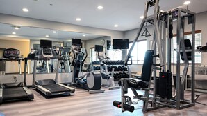 A gym with treadmills, elliptical machines, and weightlifting equipment.