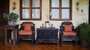 Una habitación rústica con dos sillas de madera, una mesita y una planta en maceta.