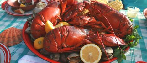 Un llagostí gran sobre un plat amb limones i pannoches.