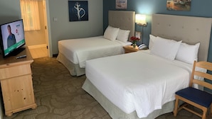 A hotel room with two beds, a television, a wooden dresser, and artwork on the walls. - The Lodge at Turbat's Creek (Kennebunkport)
