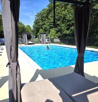 Una piscina al aire libre de temporada, sillones reclinables de piscina