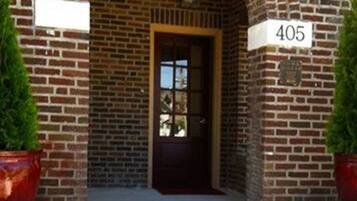 A brick building with a large arched entrance, a door, and a number sign '405'.
