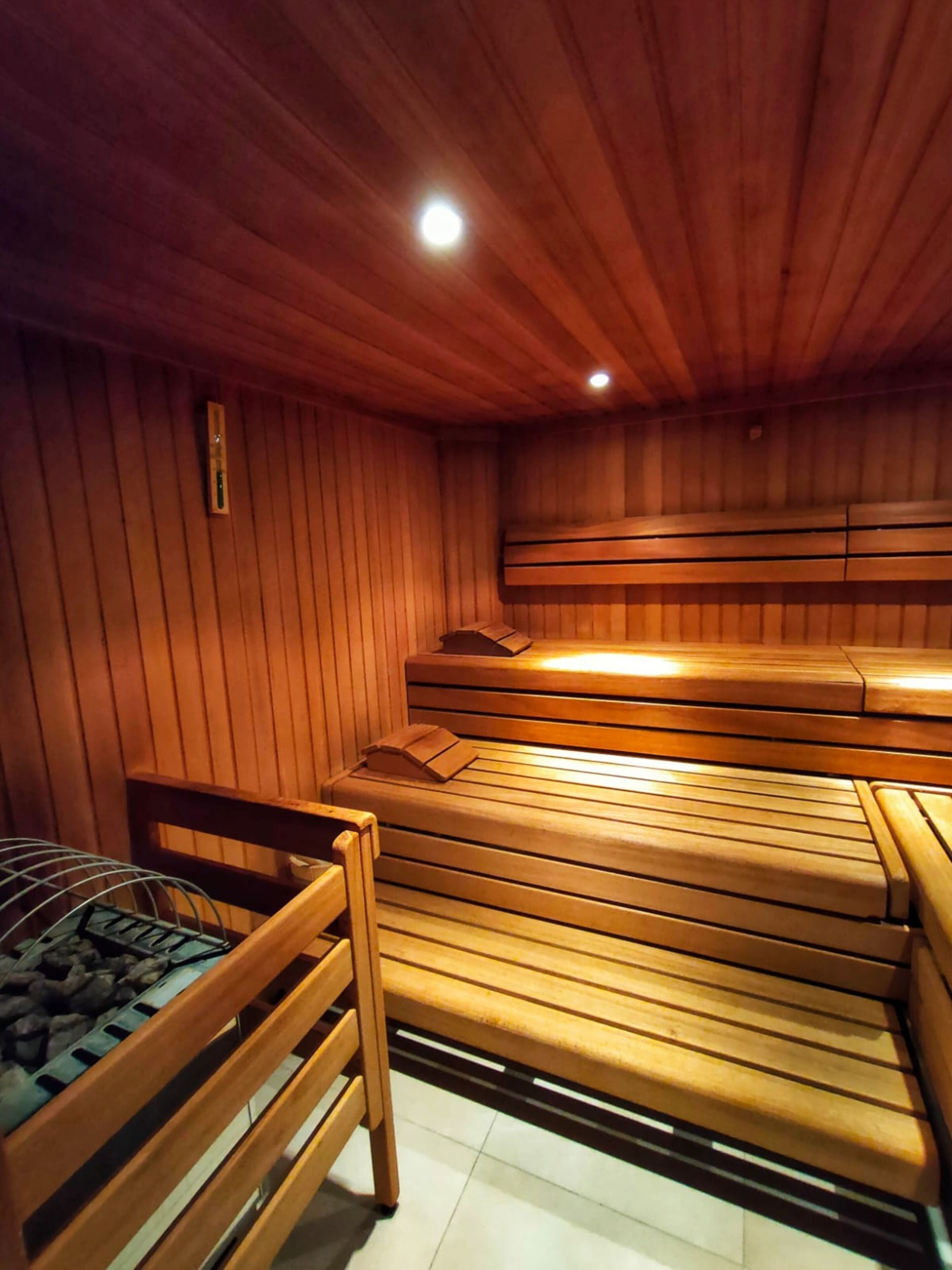 A sauna with wooden benches and a bench with a towel.