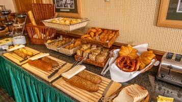 Ein reichhaltiges Buffet mit verschiedenen Brotsorten, Gebäck und einem Toaster.
