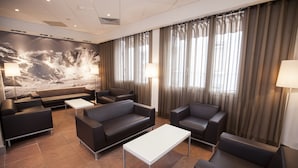 A modern hotel lobby with leather sofas, a white coffee table, and a large abstract mural on the wall. - Hotel Florida (Lourdes)