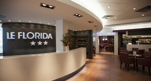 A reception area with a 'LE FLORIDA' sign, a bar, and a restaurant. - Hotel Florida (Lourdes)