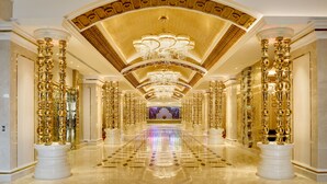 A luxurious hallway with ornate columns, a grand chandelier, and a reflective floor. - NagaWorld Hotel & Entertainment Complex (Phnom Penh)