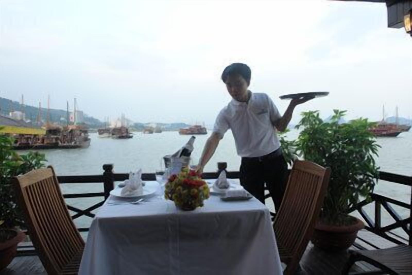 A table set for dining with a view of the harbor.