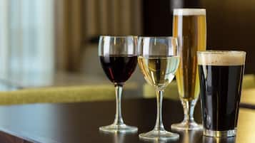 Cuatro vasos de diferentes bebidas sobre una mesa de madera.