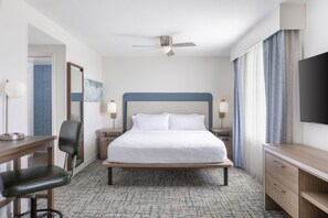 A hotel room with a bed, bedside tables, a desk, a chair, a television, and a ceiling fan. - Homewood Suites by Hilton Lake Buena Vista - Orlando (Orlando)