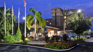 A hotel with a fountain, palm trees, and flags. - Homewood Suites by Hilton Lake Buena Vista - Orlando (Orlando)