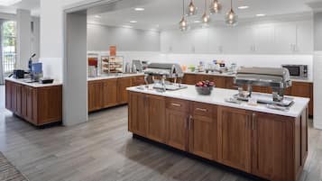 A modern kitchen with wooden cabinets, a central island, and various appliances.