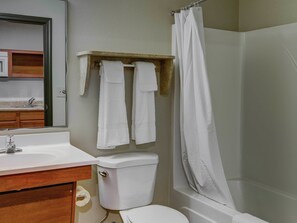 A bathroom with a toilet, sink, and shower.