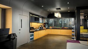 A modern kitchen with a built-in microwave, a coffee machine, and a large window offering a view of the outdoors. - Aloft by Marriott Arundel Mills BWI Airport (Hanover)