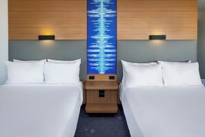 A hotel room with two beds, a central wall-mounted digital display, and bedside lamps. - Aloft by Marriott Tempe (Tempe)