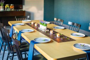 Una mesa de comedor con platos, velas y pequeñas macetas.