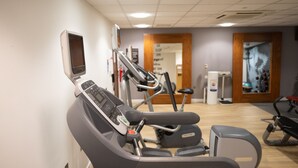 A gym with cardio machines, a treadmill, and a stationary bike. - Hampton by Hilton Corby/Kettering (Corby)