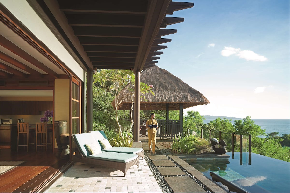 Ein modernes Resort mit Pool, Liegestühlen und Meerblick.