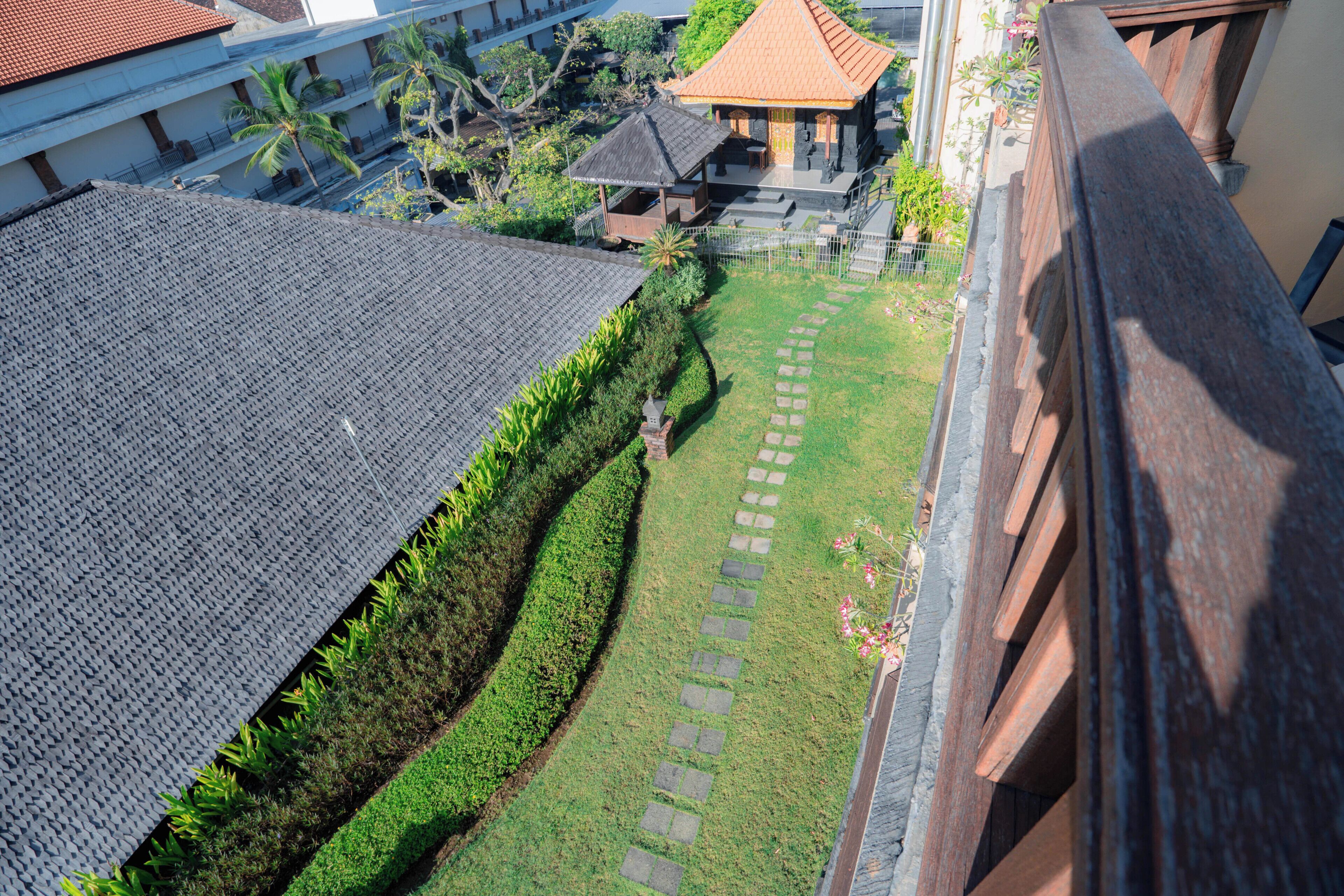 An aerial view of a courtyard with a stone pathway, a gazebo, and a building with a tiled roof.