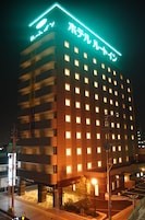 A multi-story hotel with illuminated signage and windows.