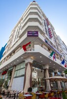 Um hotel com uma placa grande que diz "HOTEL ZAHRAAT JABAL" e várias bandeiras.