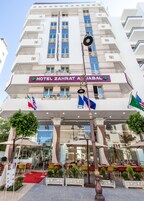 Um hotel com uma placa de destaque que diz "HOTEL ZAHRAT AL JABAL".